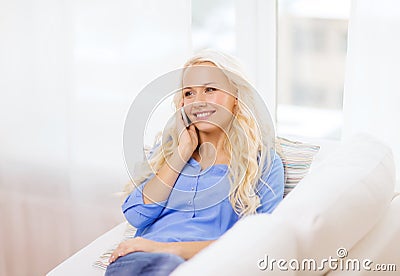 Smiling woman with smartphone at home