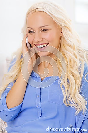 Smiling woman with smartphone at home