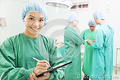 Smiling woman surgeons writing patient operating records