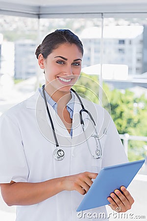 Smiling young doctor using tablet pc