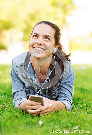 Smiling young girl with smartphone and earphones