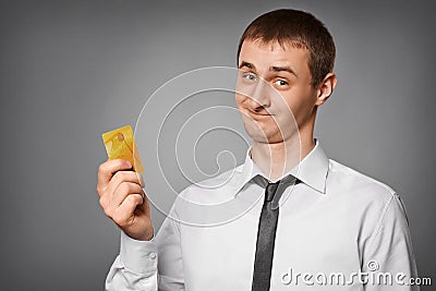 Smiling young man holding a credit card