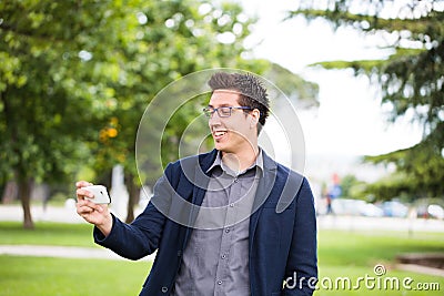 Smiling Young Man Using His Smart Phone