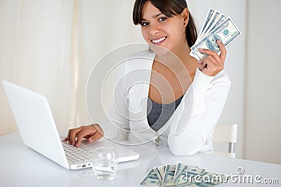 Smiling young woman holding up cash money