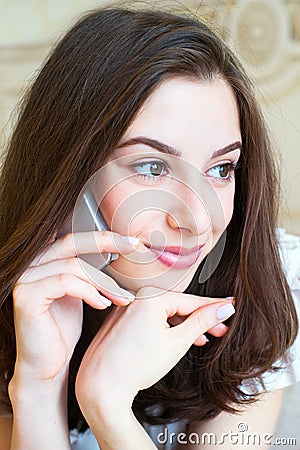 Smiling young woman talking mobile indoor