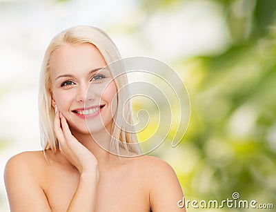 Smiling young woman touching her face skin