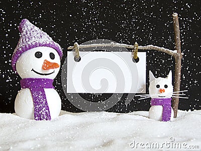 Snow man and snow cat with sign