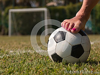 Soccer ball in a green field near a five-a-side goal, outdoor