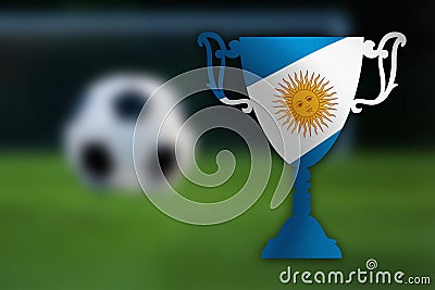 Soccer trophy with Argentina flag inside, ball and goal in the background.