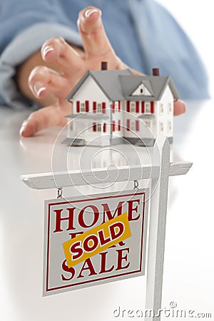 Sold Real Estate Sign in Front, Reaching for House