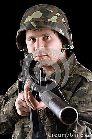 Soldier holding a gun in studio