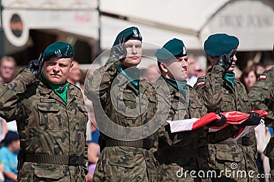 Soldier salute with Polish flag in hand (Day of Polish Army)