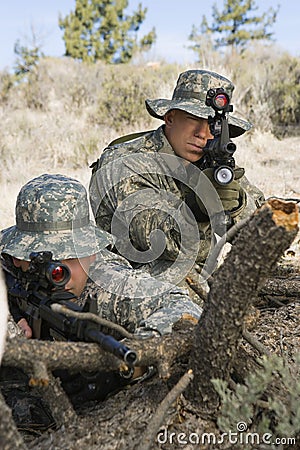 Soldiers With Machine Gun Leaning On Log