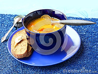 Soup from a pumpkin and carrot in dark blue a soup cup
