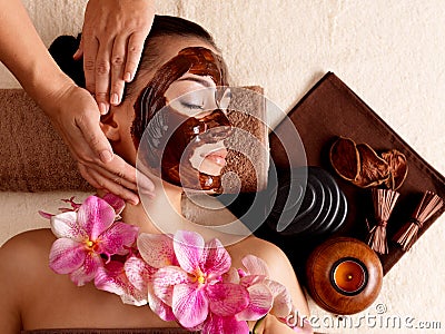 Spa massage for woman with facial mask on face