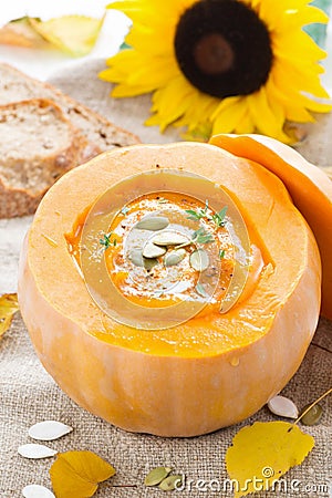 Spicy vegetable cream soup in a pumpkin and bread, vertical