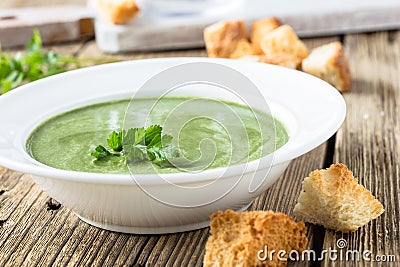 Spinach cream soup on wooden background