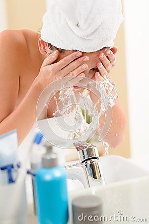 Splash in bathroom woman cleaning face