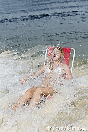 Splash: woman surprised by waves of the ocean