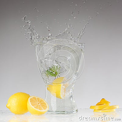 Splashes of water, lemon falling into a glass