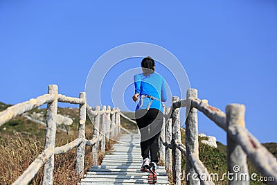 Sports woman running on mountain stairs