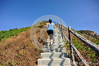 Sports woman running on mountain stairs