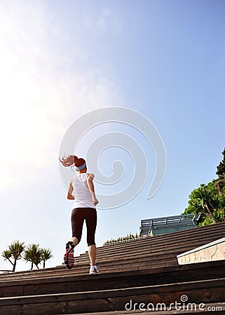 Sports woman running up on wooden stairs