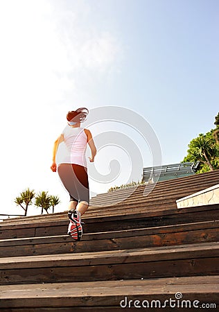 Sports woman running up on wooden stairs