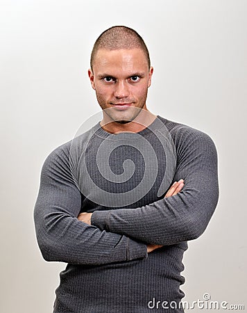Sporty male with arms folded.
