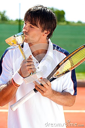 Sporty man kissing trophy