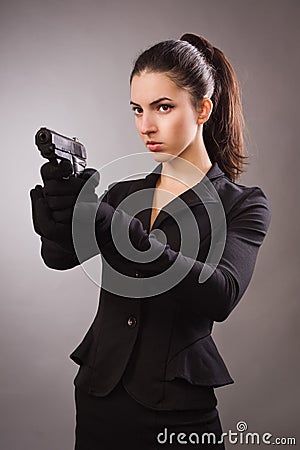 Spy girl in a black shoots a gun