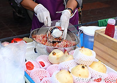 Squeezing pomegranate juice on street market, Thailand, Bangkok