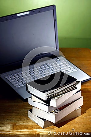 Stack of books and a Computer laptop