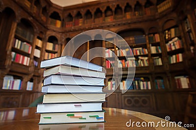 Stacked books with library in the background