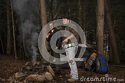 Standing around the campfire roasting hotdogs