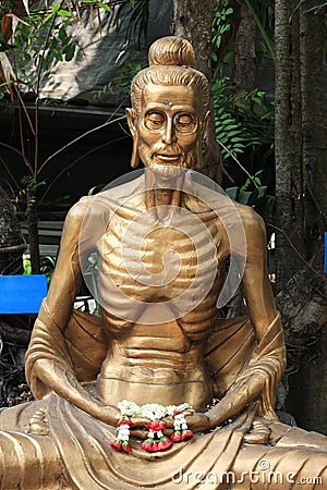 Starving Buddha statue with garland