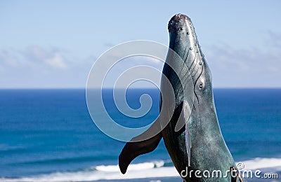 Statue of whale breaching with sea