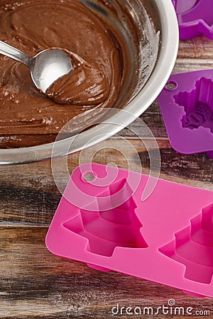 Steps of making chocolate cake: filling silicone mold with pastr