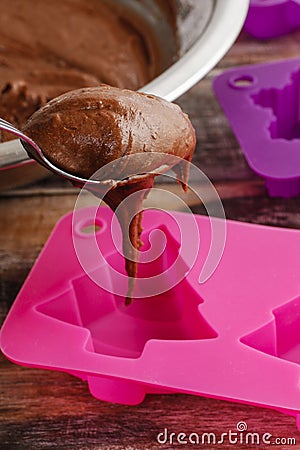 Steps of making chocolate cake: filling silicone mold with pastr