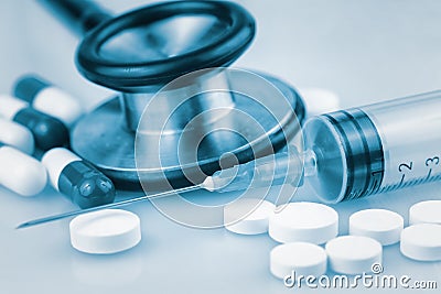 Stethoscope,pills and syringe toned in blue shades