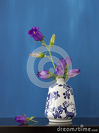 Still life of purple flowers in little vase