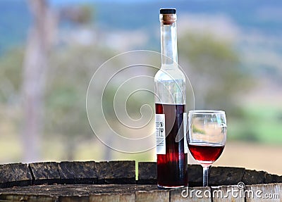 Still life red wine port bottle & glass on wood barrel