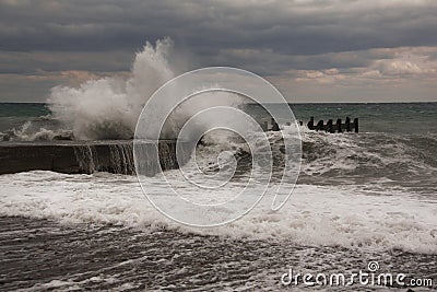 Storm waves over harbor at sea. Sea storm with waves crashing against the pier