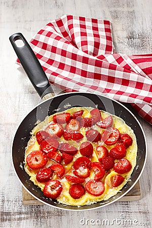 Strawberry omelette on frying pan