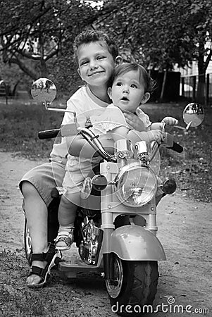 On the street hugging brother little sister, they ride on a mot