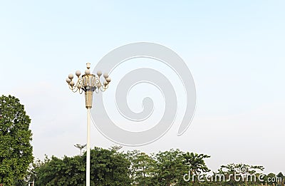 Street light lamp post on blue sky background, road lamp at top of pole