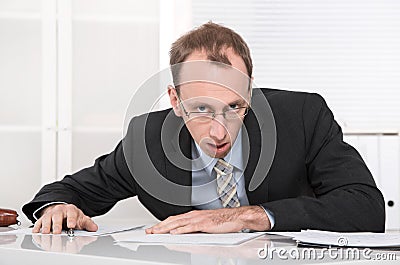 Stressed and angry businessman at desk.