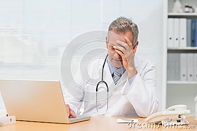 Stressed doctor sitting at his desk