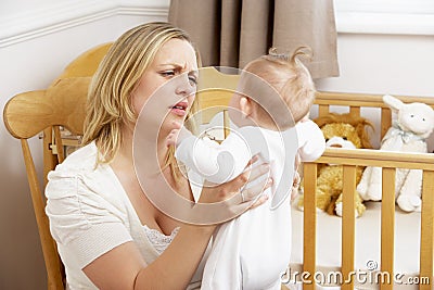 Stressed Mother Holding Baby In Nursery