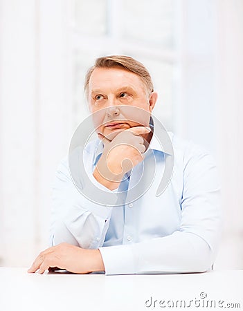 Stressed old man holding head at home